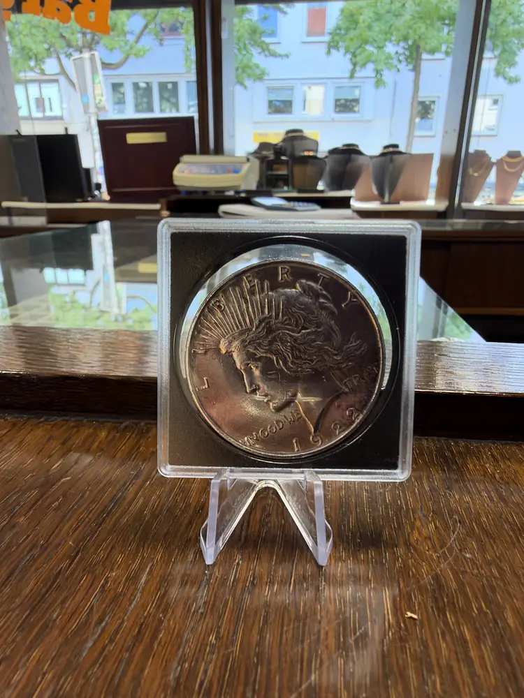 Peace-Dollar aus den USA mit Freiheitskopf in einer Münzkapsel auf einem Aufsteller