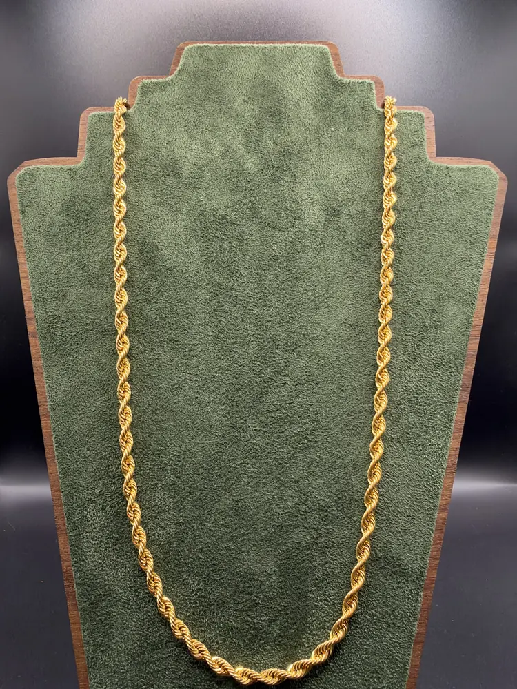 Goldene Kordelkette auf grünem Samtdisplay: Schmuck verkaufen in Bremen bei wirkaufendeingold.de
